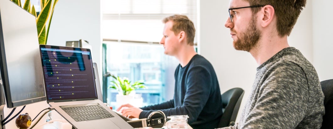 men working side by side on computers
